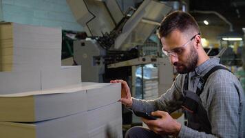 Print worker chooses paper for printing video