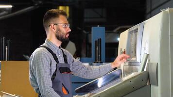 Technician operator checking input and output status on touchscreen front display monitor station in digital printshop office video
