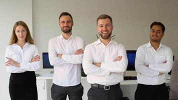 Successful business team posing with crossed arms for presentation of work while looking at camera in a coworking space video