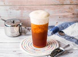 iced milk Black Tea with sugar pot and spoon served in disposable glass isolated on table side view of hong kong tea photo