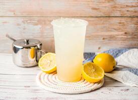 Iced Light Lemon Juice with sugar pot and spoon served in disposable glass isolated on table side view of hong kong tea photo