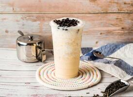 Iced Jasmine Tapioca Green Milk Tea with sugar pot and spoon served in disposable glass isolated on table side view of hong kong tea photo