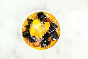 mango sago grass Jelly Yangzhi Manna Aiyu Jelly served in bowl isolated on grey background top view of asian food photo