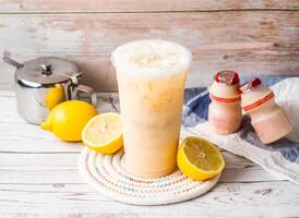 Iced Lemon Yakult Team with sugar pot and spoon served in disposable glass isolated on table side view of hong kong tea photo