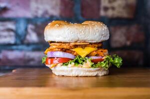 Double Chicken cheese premium Burger include chicken patty, mayonnaise, lettuce leaf, tomato and onion isolated on wooden board side view of unhealthy junk fastfood photo