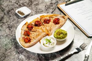Tortilla Chips with Tomato Salsa Sauce, dip, fork and knife served in plate isolated on grey marble background side view of hong kong food photo