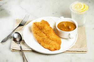Nostalgic Curry Crispy Fish Fillet Rice with lemonade, fork and spoon, served in dish isolated on napkin side view of asian food photo