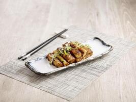 Wok fried Rice Roll with XO Chilli Sauce served in a tray with chopsticks isolated on mat side view on grey marble background photo