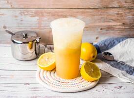 Iced Lemon Juice with sugar pot and spoon served in disposable glass isolated on table side view of hong kong tea photo