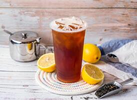 Iced lemon black tea with sugar pot and spoon served in disposable glass isolated on table side view of hong kong tea photo