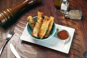 Special Spring Rolls with Sweet and Sour Sauce served in dish isolated on wooden table top view of italian fast food photo