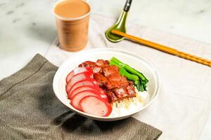 Chinese Sausage and BBQ Pork with Rice with milk kopi chopsticks and spoon served in bowl isolated on napkin side view of hong kong food on marble background photo