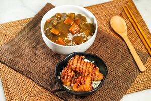 Japanese Deep Fried Chicken and Curry Rice with chopsticks and spoon served in bowl isolated on napkin side view of Japanese food photo