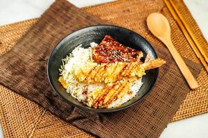 Grilled Eel with Deep Fried Shrimp Donburi with rice, chopsticks and spoon served in bowl isolated on napkin side view of Japanese food photo