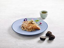 Pan fried Cod Fillet with Truffle Sauce served in a dish side view on grey background photo
