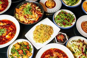 Spicy hot pot, fried rice, fried String Beans with Minced Pork, fungus, Steamed Chicken with Chili Sauce, Mapo Tofu, Bawang Chicken, boiled fish, pork belly, served side view of hong kong food photo
