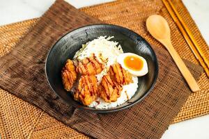 Japanese Deep Fried Chicken Donburi with Rice, chopsticks and spoon served in bowl isolated on napkin side view of Japanese food photo