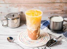 iced Taro Green Tea with Fresh Milk with sugar pot and spoon served in disposable glass isolated on table side view of hong kong tea photo