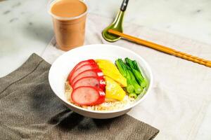 Chinese Sausage and Poached Chicken with Rice with milk kopi chopsticks and spoon served in bowl isolated on napkin side view of hong kong food on marble background photo