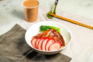Chinese Sausage and Roasted Duck with Rice with milk kopi chopsticks and spoon served in bowl isolated on napkin side view of hong kong food on marble background photo