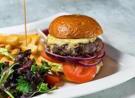 Wagyu Beef Burger with tomato, onion, cabbage and french fries served in dish isolated on background side view of italian food photo