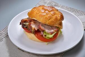 Barbecued Pork Tomato Pineapple Buns with tomato and lettuce leaf served in dish isolated on napkin top view of chinese food on grey background photo