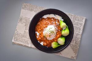 Hot spring egg and beef rice served in bowl isolated on napkin top view of chinese food on grey background photo