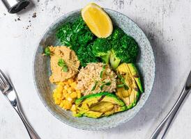 Grilled Avocado Bowl with broccoli, corn, lettuce, fried rice and lemon served in bowl isolated on background top view of italian food photo