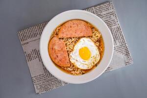 beef, sunny side up fried egg and instant noodle served in dish isolated on napkin top view of chinese food on grey background photo
