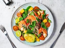 Prawn and Avocado Salad with cherry tomato, orange, lemon, mint, coriander, and onion served in plate isolated on background top view of italian food photo