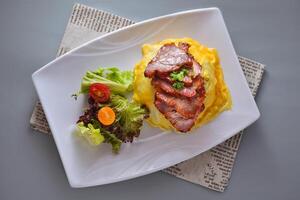 Honey Glazed Pork Omelette Rice with salad served in dish isolated on napkin top view of chinese food on grey background photo