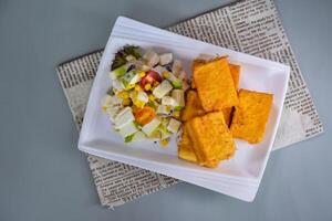 Golden Brick West Toast and Green Apple Salad with corn, cream and tomato served in dish isolated on napkin top view of chinese food on grey background photo