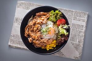 Japanese beef hot spring egg rice bowl with corn and salad served in bowl isolated on napkin top view of chinese food on grey background photo