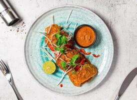 Crab Cakes with Thai Red Curry Sauce served in plate isolated on background top view of italian food photo