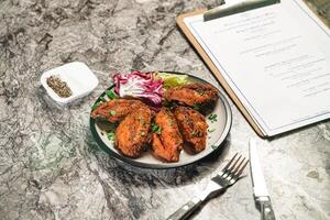 Crispy Chicken Wings with dip, fork and knife served in plate isolated on marble background side view of hong kong fastfood photo