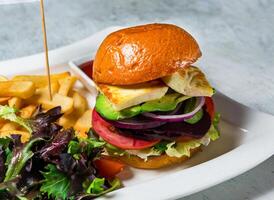 Veggie Burger with tomato, onion, lettuce, beetroot, cheese, and french fries served in dish isolated on background side view of italian food photo