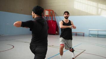Guys Warm Up by Turning Their Torsos In the Gym video