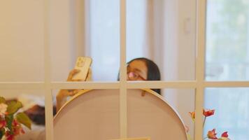 Selective focus on a white grid with a blurred background where a person's eyes are peeking through video