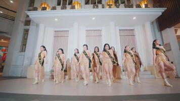 Group of dancers in golden costumes performing a synchronized routine in a mall with elegant interior design video