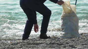 Man Picking Up Trash on a Beach video