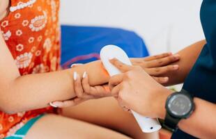 Modern laser physiotherapy on woman patient. Laser therapy used on the arm to treat pain, Close up of physiotherapist using laser therapy on patient arm photo