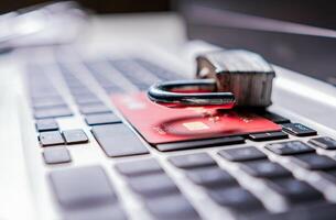 Open padlock with credit card on keyboard. Concept of theft of information on credit cards. Padlock on top of credit card on laptop keyboard photo