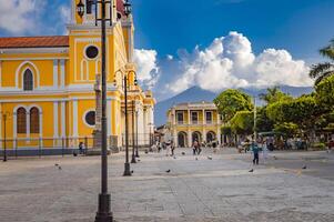 Beautiful plaza with people around in a sunset, plaza with a church with people around, plaza de granada nicaragua photo