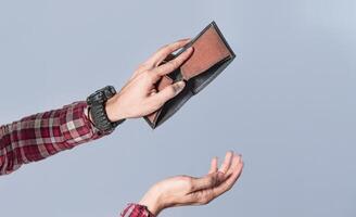 Concept of an empty wallet, hand opening empty wallet on isolated background, concept of economic crisis photo
