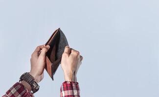 Concept of an empty wallet, hand opening empty wallet on isolated background, concept of economic crisis photo