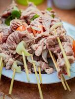 Close up of raw beef meat skewers with ingredients. Fresh and raw beef skewers on a plate. Raw beef skewers on a plate. Preparation of raw beef skewers. photo
