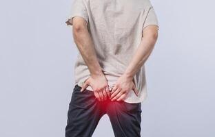 Man with diarrhea problem isolated. Person with digestive problem touching his buttock, man with hemorrhoid problem isolated photo