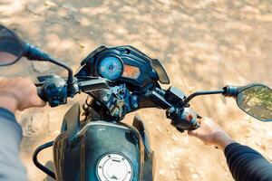 View of motorcyclist on the handlebars. View of the hands on the handlebars of a motorcycle, Hands of man on the motorcycle handlebars photo