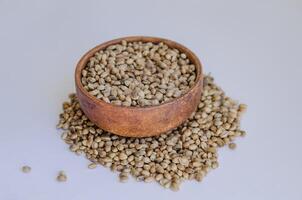Hemp seeds in wooden plate on white background. High quality photo