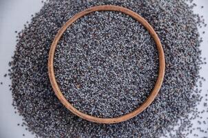 poppy seeds in wooden bowl on white background. High quality photo